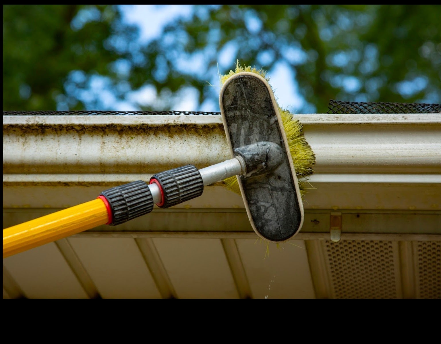 cleaning the gutter with a scrub brush